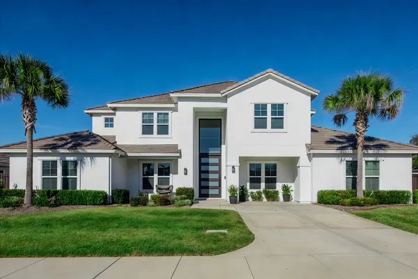 Modern white two-story home with palm trees, Orlando FL real estate