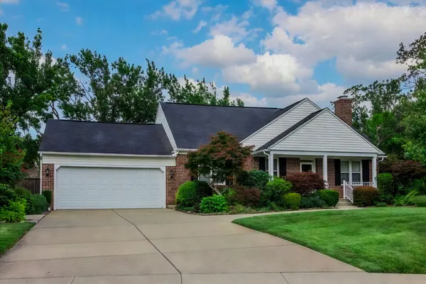 Brick ranch home with mature trees and well-kept lawn