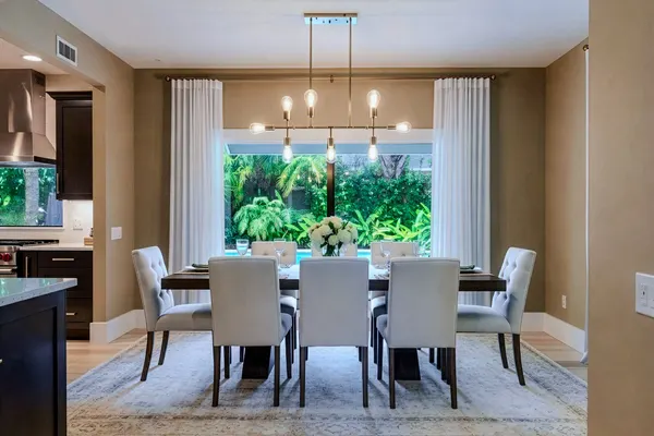 Elegant dining room with linear chandelier and garden view