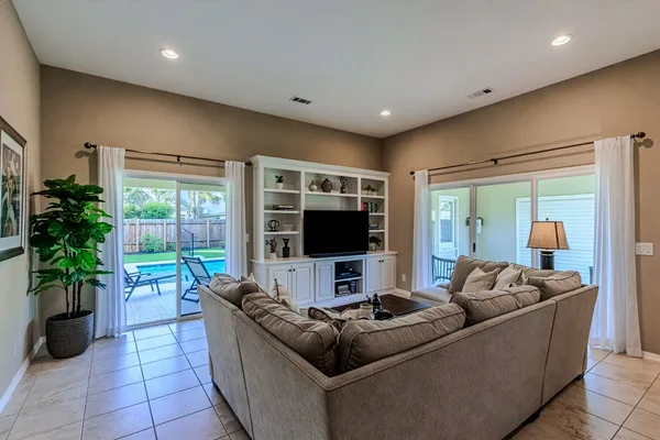 Family room with built-in entertainment center and sliders to pool patio