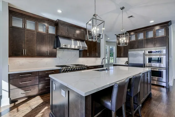 Luxury kitchen with espresso cabinets, marble island and lantern pendants